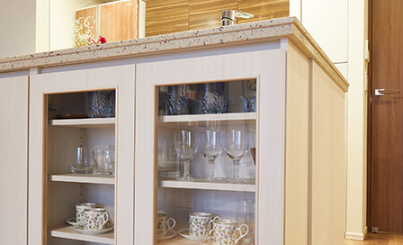 カウンター下のスペースを利用して作りつけた食器棚は、色が本棚の背板とお揃い。ガラス扉の奥にはお気に入りの食器類を飾っている。
