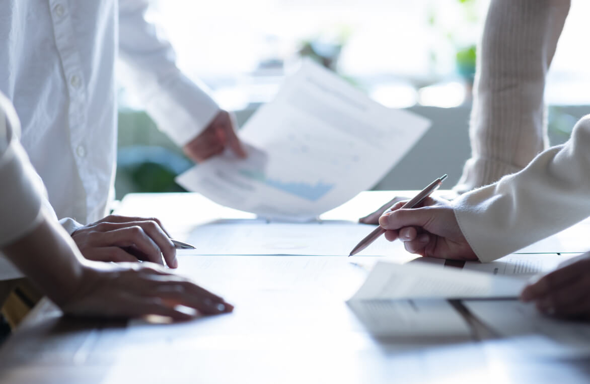 書類をペンで指し打ち合わせしている