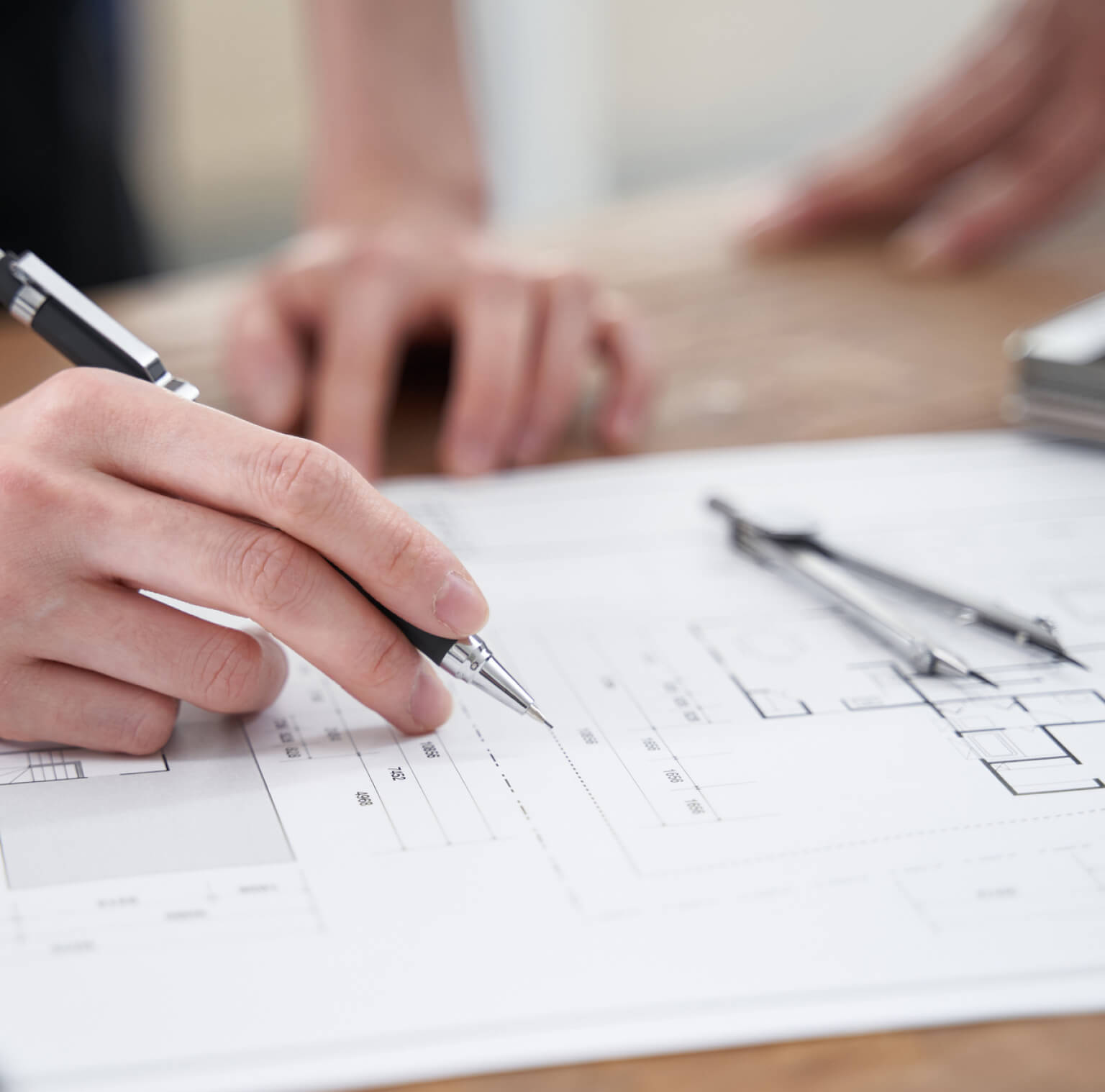 ペンで図面に製図している