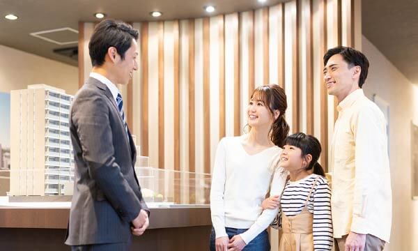 模型コーナーで3人の家族にご案内している男性