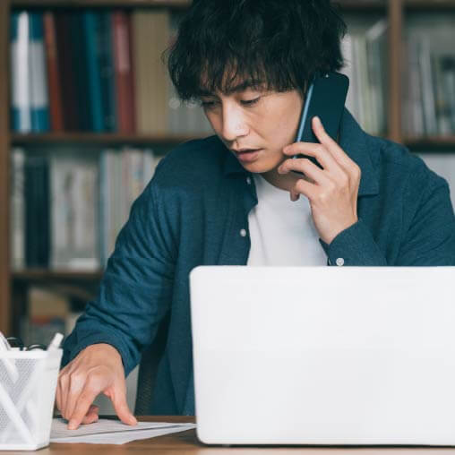 パソコンを開いて勉強する男性