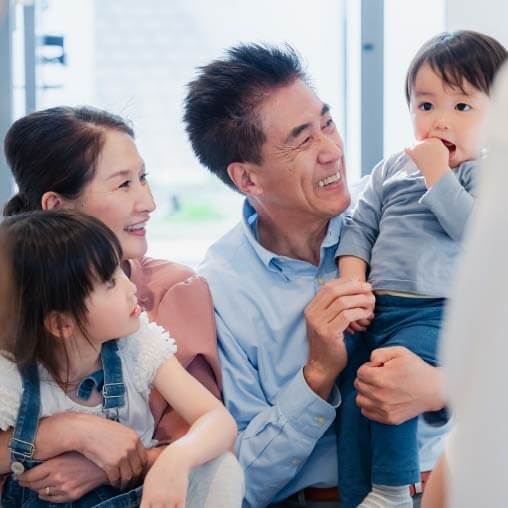 男性と女声が笑顔でこどもを抱いている
