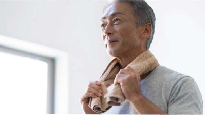 タオルを首にかけている男性